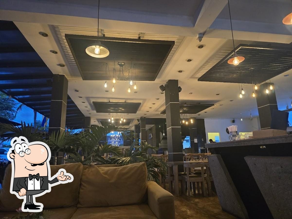 Zona lounge de Carantanta con sofás, plantas y luces colgantes